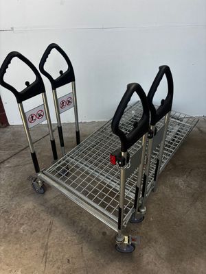 three black and silver shopping carts sitting in a garage