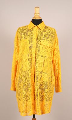 une photo d'une chemise jaune posée sur un présentoir pour mannequin