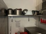 many pots and pans on the shelves in the kitchen