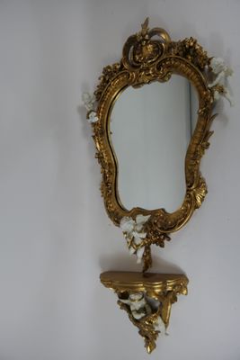un miroir accroché au mur au-dessus d'une étagère sur laquelle se trouve un miroir