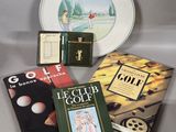 several books and a plate on a table with a plate in the background