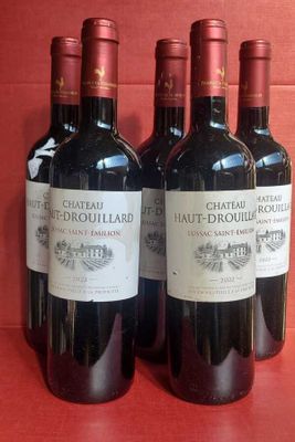 three bottles of red wine are lined up on a red surface