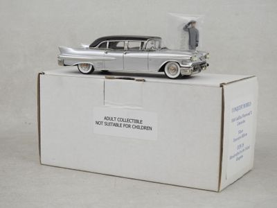 une petite voiture en argent posée sur une boîte