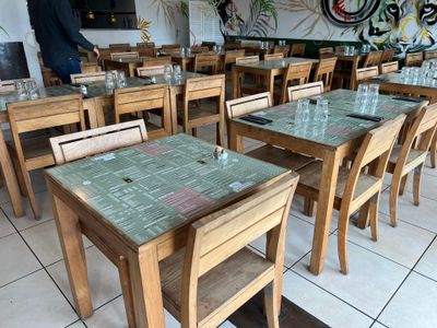 de nombreuses tables et chaises dans un restaurant dont les murs sont couverts de graffitis
