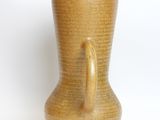a brown vase that is sitting on a white surface