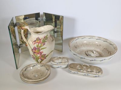 un vase, un bol, une assiette et un miroir posés sur une table