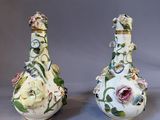 pair of porcelain vases with floral designs on them on a gray background