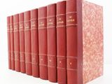 six livres rouges alignés sur une surface blanche