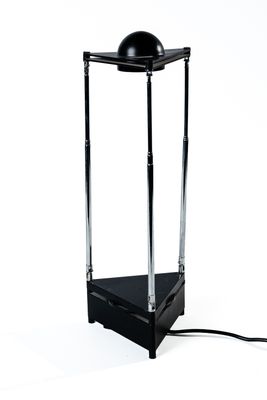 une lampe posée sur un pied, sur une surface blanche