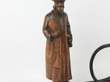 a wooden statue of a man with a hat and a cane