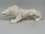 une figurine de lion blanc posée sur une table