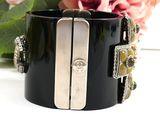 black and silver cuff bracelet with a flower in the background