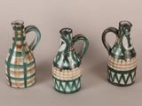 three green and white vases sitting next to each other on a table