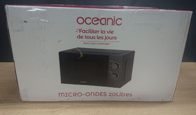 packaging of a microwave sitting on a table in front of a blue wall