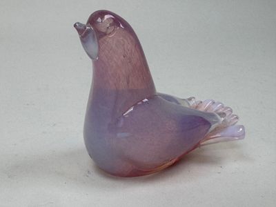un oiseau en verre posé sur une table