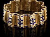 un gros plan d'un bracelet en or orné de fleurs bleues