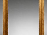 un miroir à cadre doré orné d'un liseré de perles sur les bords