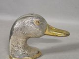 a silver and gold duck figurine sitting on a table