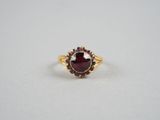 Gros plan sur une bague contenant une pierre rouge