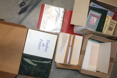 une boîte de livres et une paire de ciseaux posés par terre