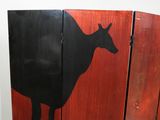 painting of a cow on a wooden panel in a bathroom
