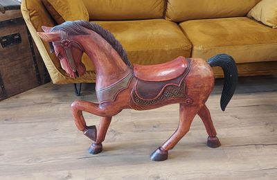 un cheval de bois posé sur un parquet
