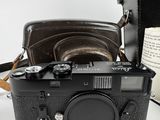 a black camera sitting next to a book on a table