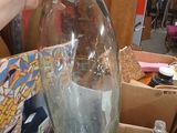a person that is holding a glass bottle in a box