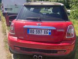 une petite voiture rouge garée sur le bord de la route