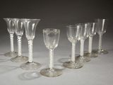 plusieurs verres à vin vides sont alignés sur une surface blanche