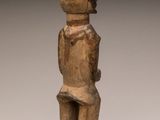 a wooden statue of a man with a hat on his head