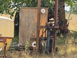 a tractor that is sitting in the grass next to a tree
