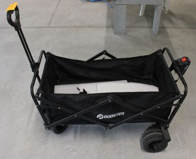 un chariot noir muni d'une poignée noire posée au sol
