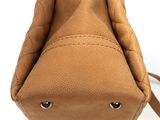 the back view of a tan purse with a strap on it