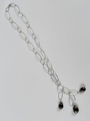 collier à chaîne en argent avec des perles noires sur fond blanc
