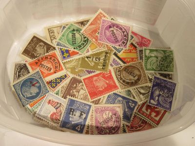 de nombreux timbres différents dans une boîte en plastique posée sur la table