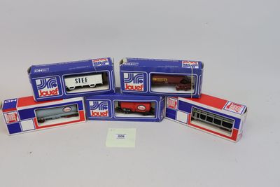 quatre boîtes contenant des trains miniatures, posées sur une surface blanche