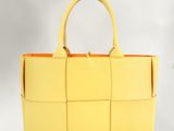 a close up of a yellow handbag on a white background