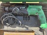 une perceuse électrique verte et noire dans une boîte à outils