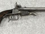gros plan d'un pistolet sur une table à fond blanc