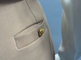 a white mannequin with a gold button on it