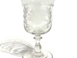 a glass with a design on it sitting on a table