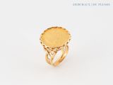 a close up of a gold ring on a white surface
