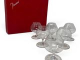 several empty wine glasses and a red box on a white surface