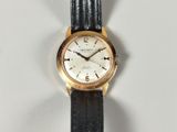 a close up of a watch on a white surface