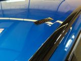 a close up of a blue car with a sticker on it