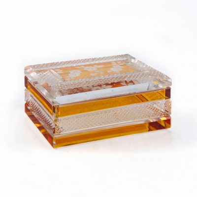 a glass box with a gold and white design on it