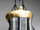 black and white and gold sculpture of two people sitting on top of a black and white chair