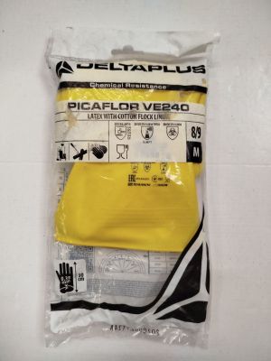 un gros plan sur un sachet de gants jaunes posé sur une surface blanche