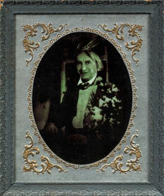 portrait of a man in a tuxedo holding a bouquet of flowers